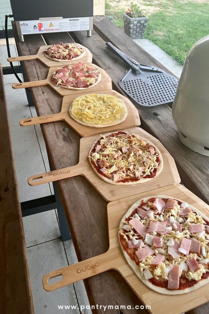 Pizzas caseras alineadas en una mesa de madera.