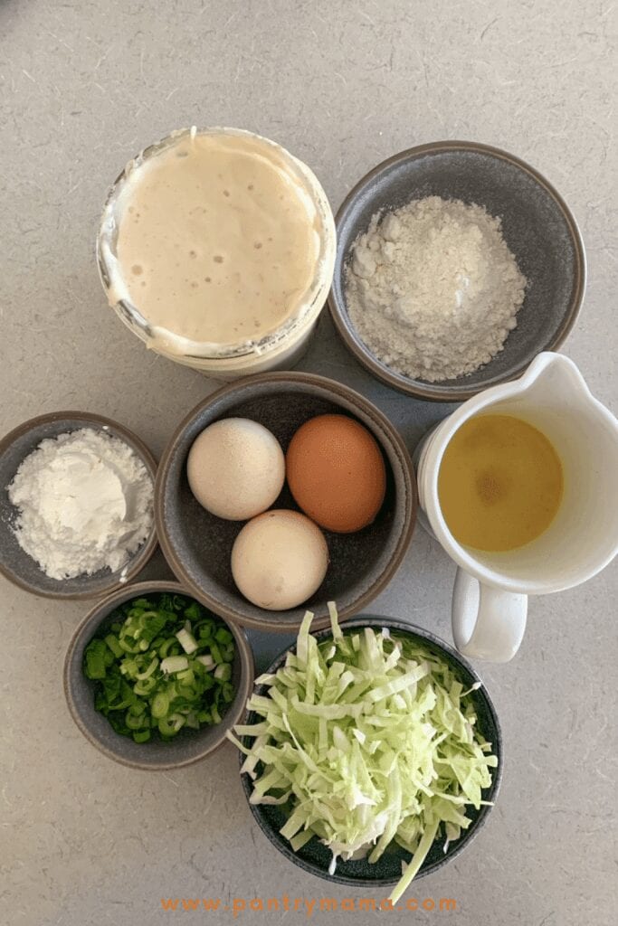 Ingredientes para tortitas de masa fermentada saladas: masa fermentada, harina de maíz, harina para todo uso, repollo, huevos, cebolletas.