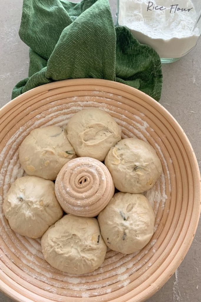 Evita que la masa madre se pegue a los bannetons usando harina de arroz.  Esta foto muestra 6 bolas de masa colocadas en un banneton redondo espolvoreado con harina de arroz.