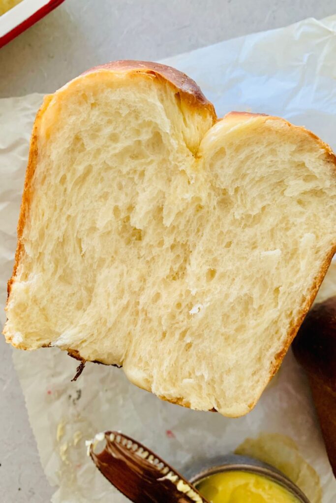 Una hogaza de pan brioche de masa fermentada que se ha abierto para mostrar la miga blanda.