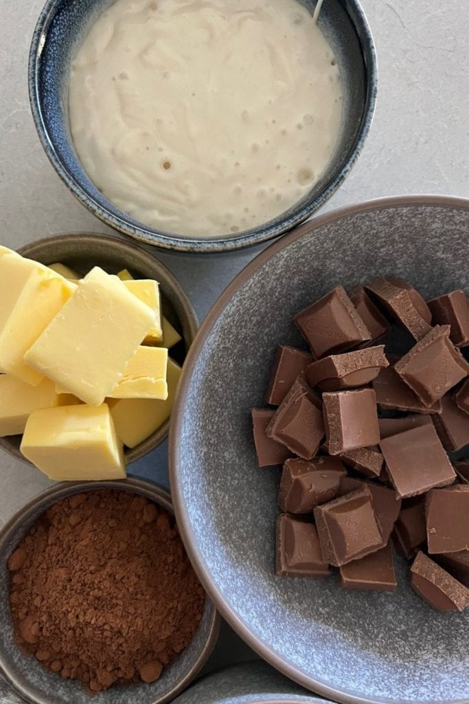 Ingrediente de brownie de masa fermentada de cerca: iniciador de masa fermentada, mantequilla, chocolate y cacao.